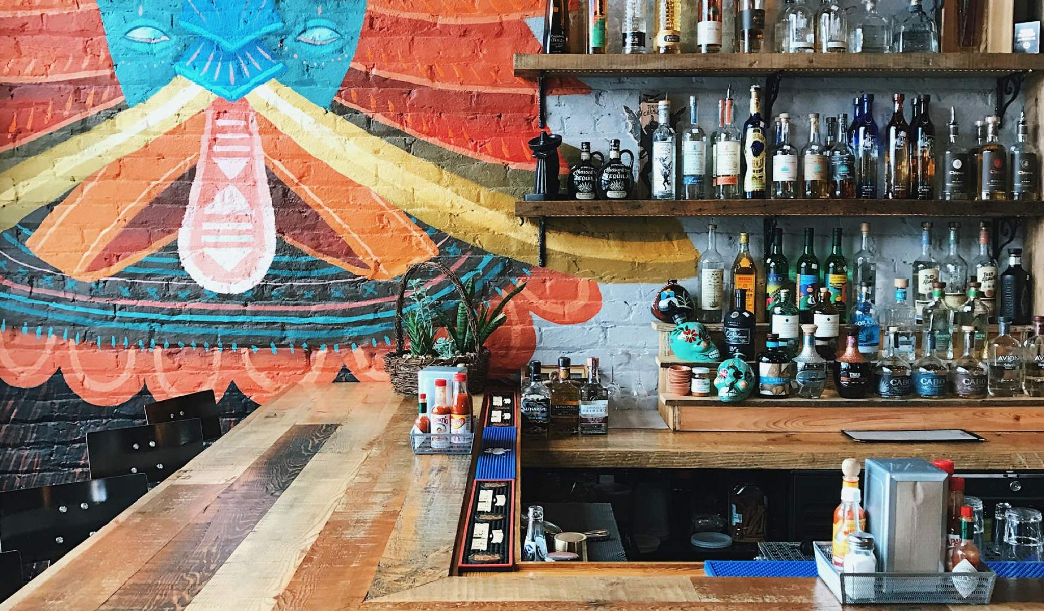 Bright and colorful restaurant featuring a wooden bar top and a mural on the wall near chapel hill north apartments 