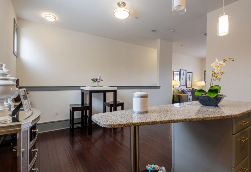 Chapel Hill North Apartments kitchen with granite kitchen island looking out into a dining area with a small bar style table