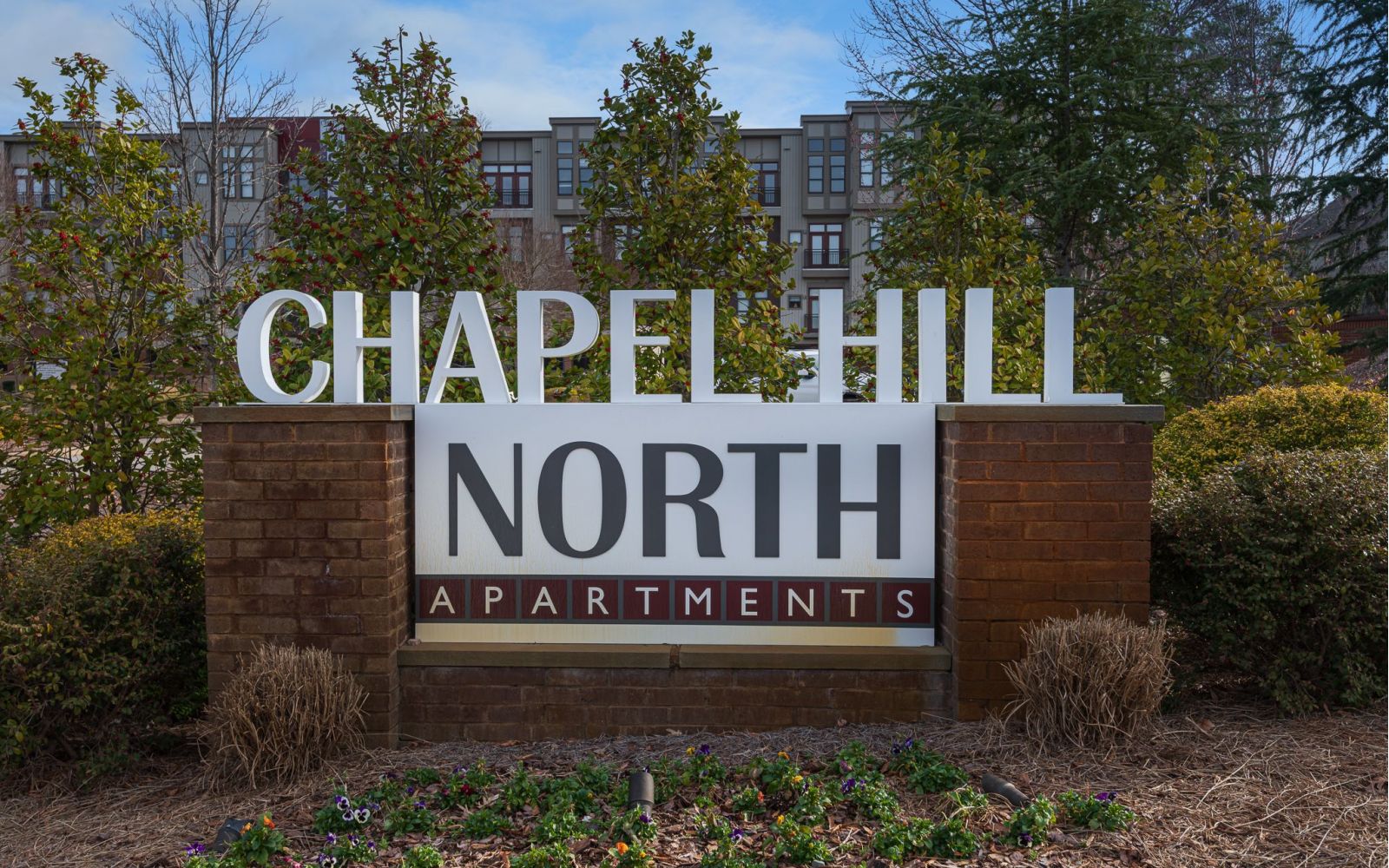 Chapel Hill North Apartments exterior sign that reads "Chapel Hill North Apartments" In red and white color scheme
