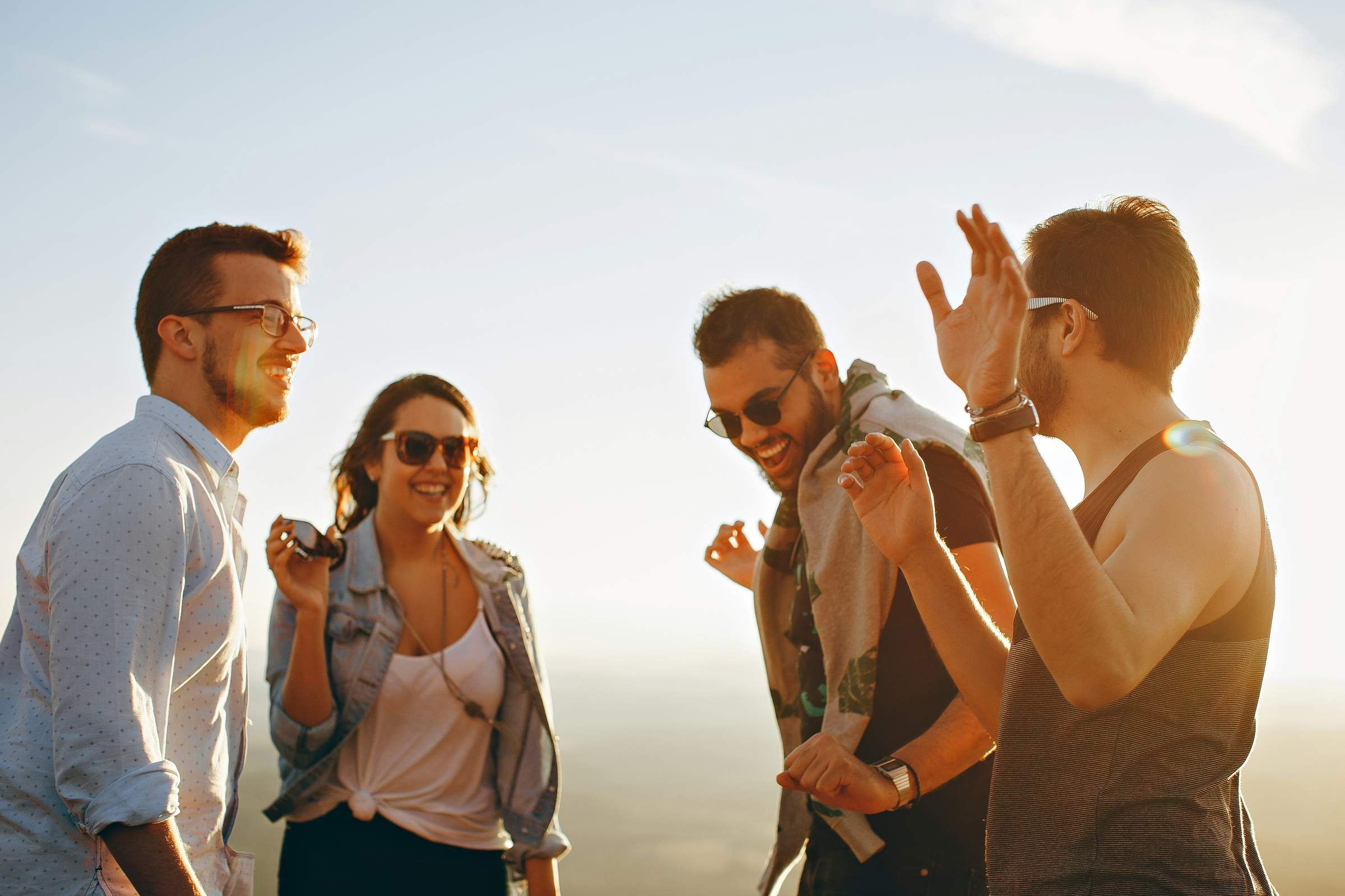 group of friends standing in a circle dancing and looking happy