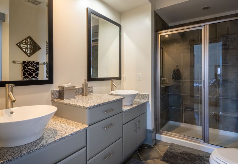 Chapel Hill North apartments spa like bathroom featuring vessel sinks, granite countertops, and walk in shower