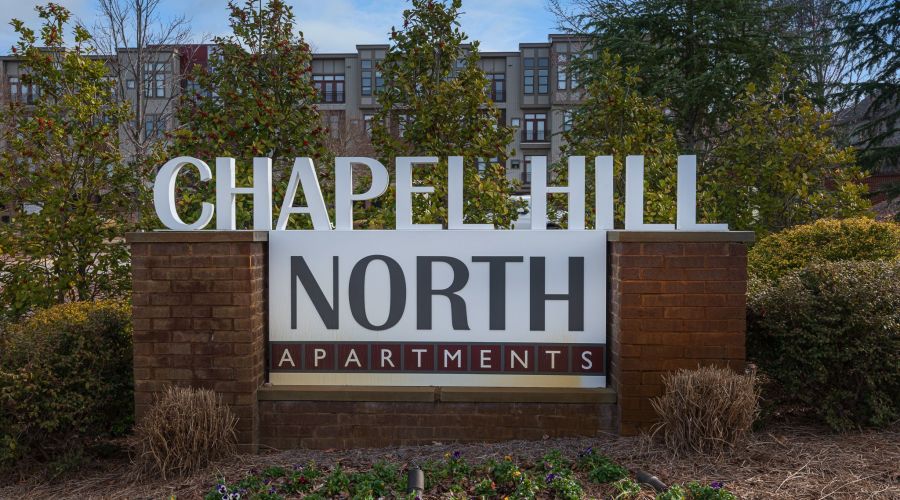 Chapel Hill North Apartments exterior sign that reads "Chapel Hill North Apartments" In red and white color scheme