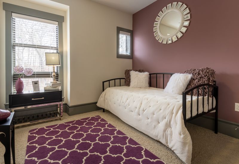 Chapel Hill North apartments modern bedroom with frieze carpeting and a twin size bed next to a purple accent wall