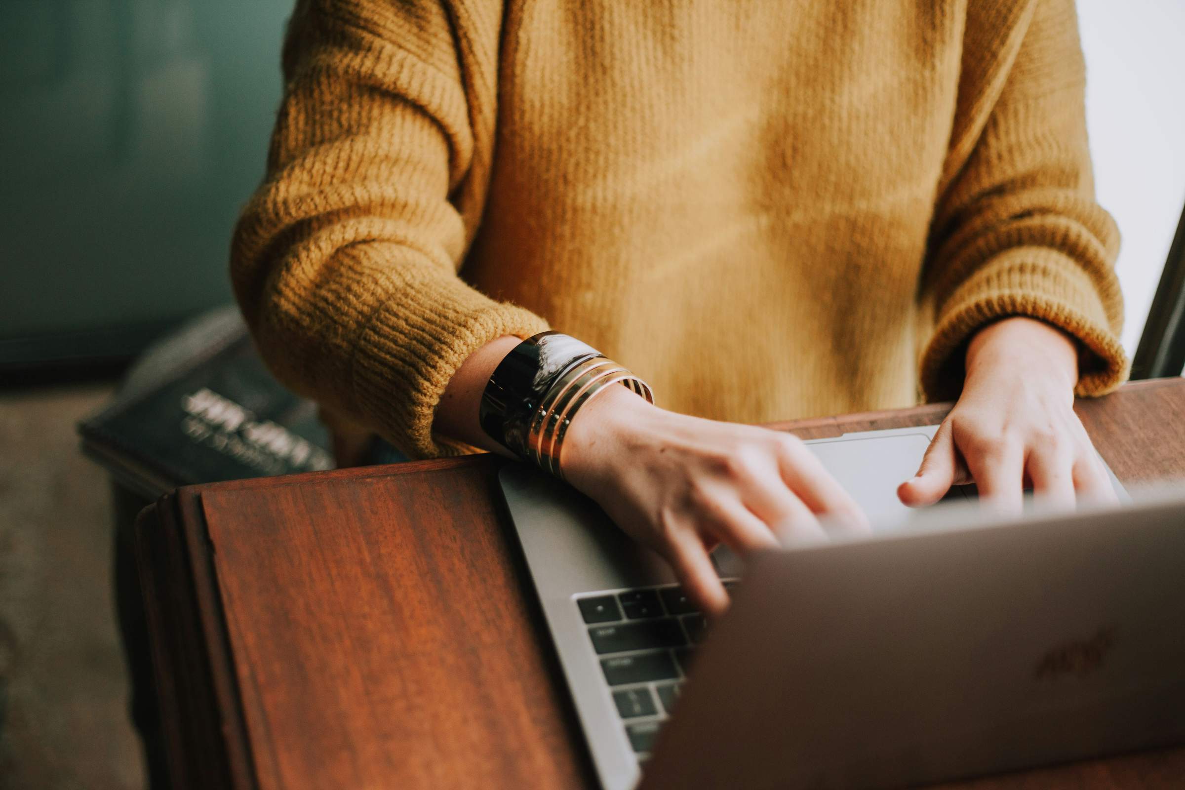 close up of a woman wearing a yellow shirt working on a laptop computer at chapel hill north apartments