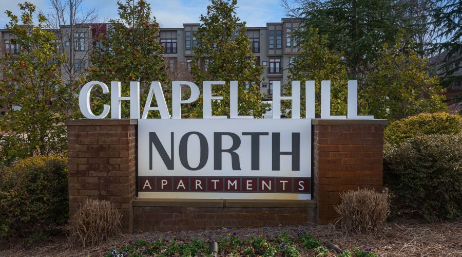 Chapel Hill North Apartments exterior sign that reads "Chapel Hill North Apartments" In red and white color scheme