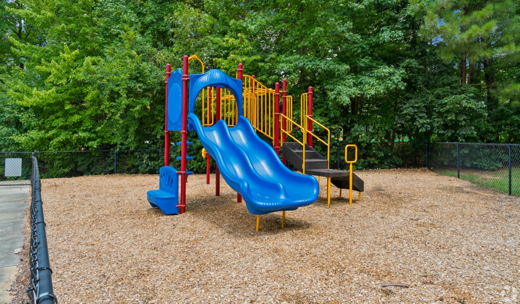 Chapel Hill North apartments outdoor kids playground area in fenced in outdoor space