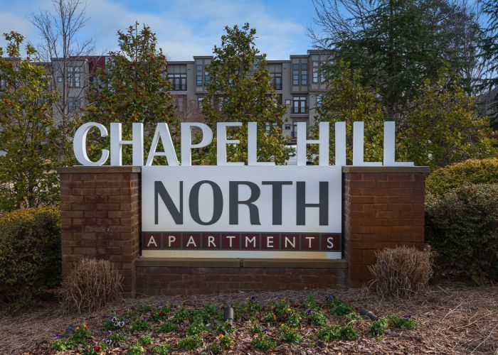 Chapel Hill North Apartments exterior sign that reads "Chapel Hill North Apartments" In red and white color scheme